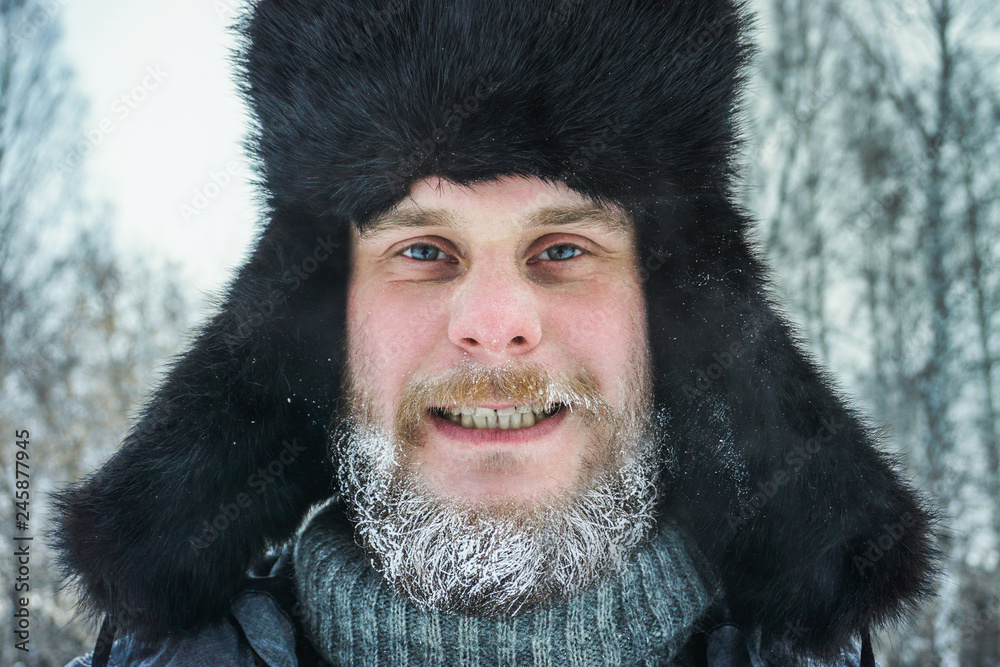 frozen man with a beard in winter in a forest with snowdrifts fell ill from the cold after a walk in the village