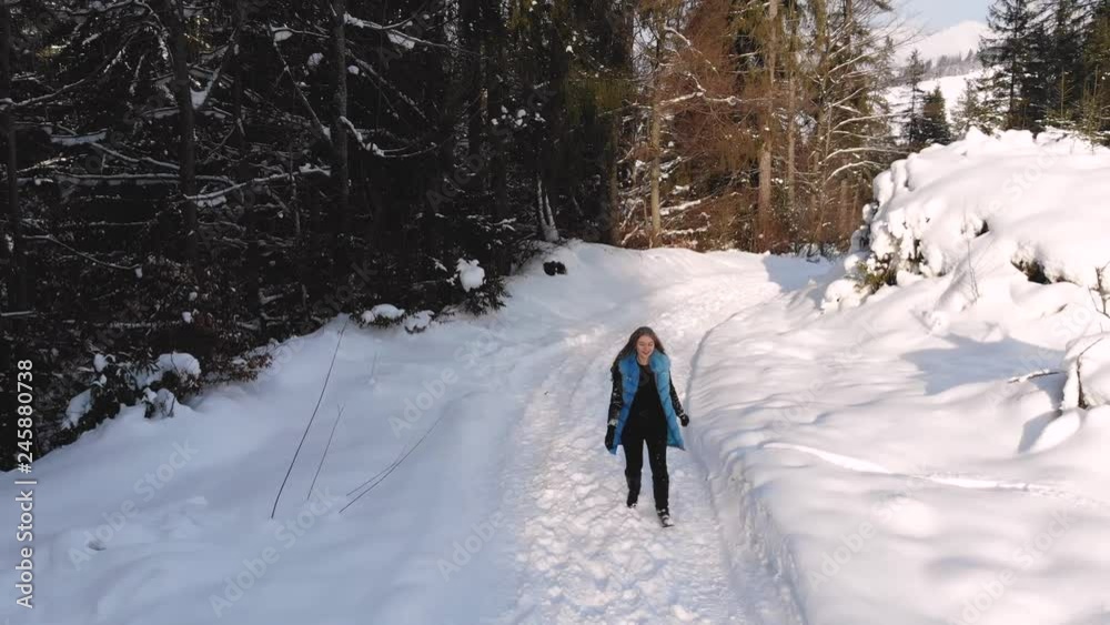 Young beautiful girl runs in a snowy winter forest. She is happy and cheerful. Beautiful blonde. Shooting from the quadcopter. Slow motion. Young beautiful girl runs in a snowy winter forest. She is happy and cheerful. Beautiful blonde. Shooting from the quadcopter. Slow motion.