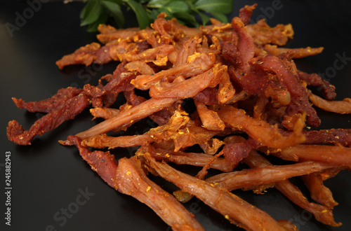 dried chicken meat on a black background with bay leaves