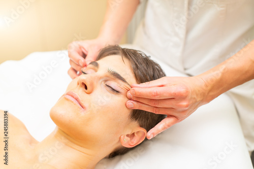 A relaxing aesthetic massage for a young woman with a face with eye draw