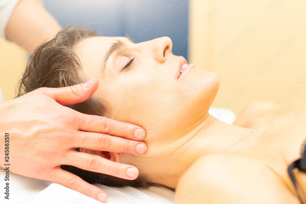 Beautician practices a relaxing beauty massage to a young woman