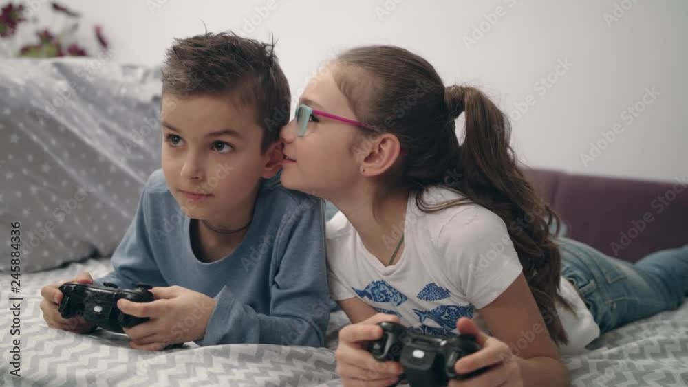 Happy kids playing video game with joystick at home. Friends play game console Happy kids playing video game with joystick at home. Friends play game console