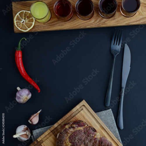 Shots on wooden board near cutlery and pepper 