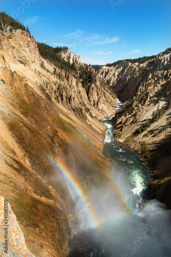 Yellowstone canyon, river, waterfall, water mist. Rainbow above the Lower Falls of the Yellowstone River. Wyoming, USA 
