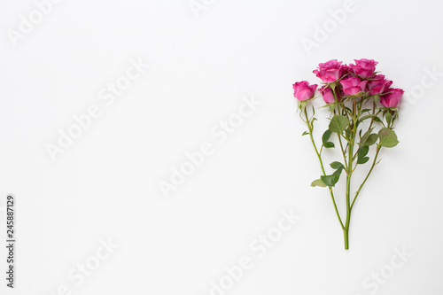 Flowers composition. Frame made of red rose on white wooden background. Flat lay, top view, copy space.