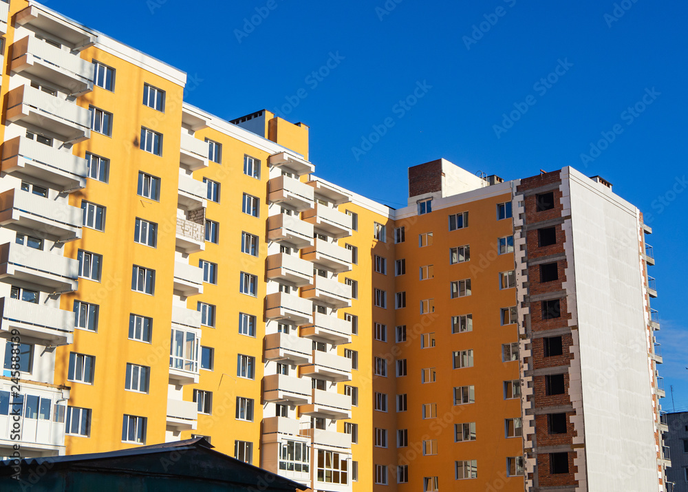 Thermal exterior insulation of new multi-storey building under clear blue sky