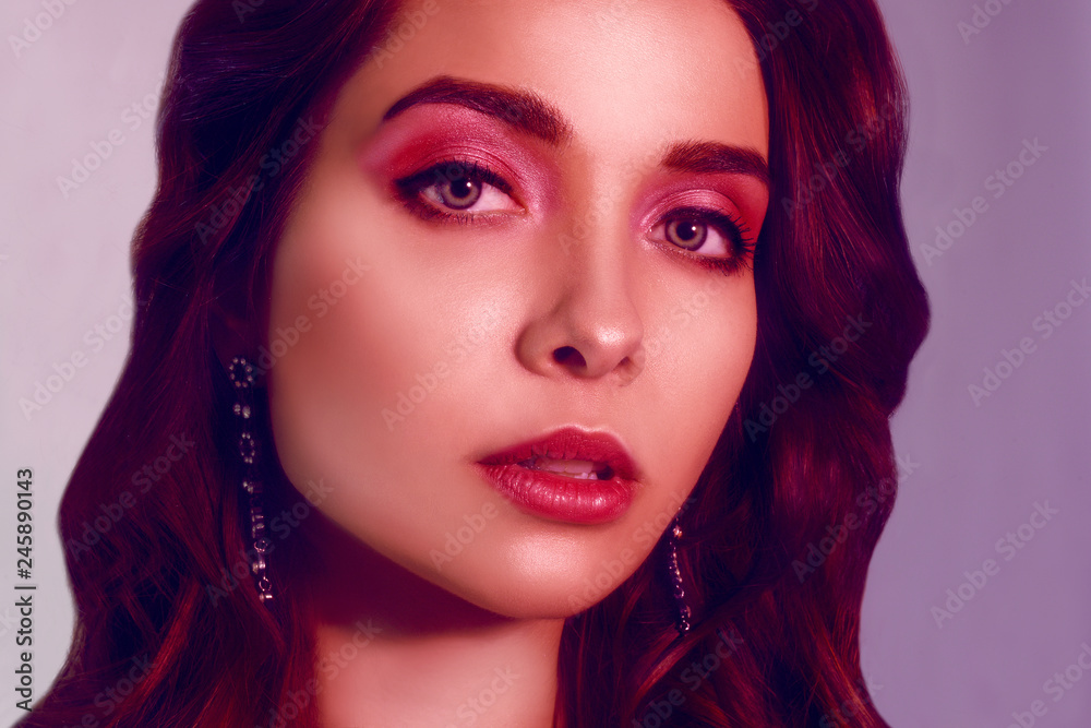 Fashion portrait of young elegant girl in jewelry. Colored background, studio shot. Beautiful brunette woman. Girl posing in neon light. Woman with stylish hair and pink lips and cerly hair. Beauty. Fashion portrait of young elegant girl in jewelry. Colored background, studio shot. Beautiful brunette woman. Girl posing in neon light. Woman with stylish hair and pink lips and cerly hair. Beauty.