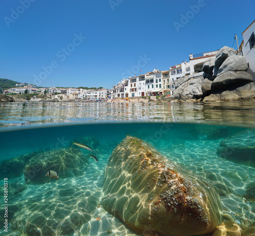 Spain Calella de Palafrugell seaside village with rocks underwater, Costa Brava, Mediterranean sea, Catalonia, split view half over and under water