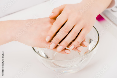Cropped view of beautiful female hands in glass bowl
