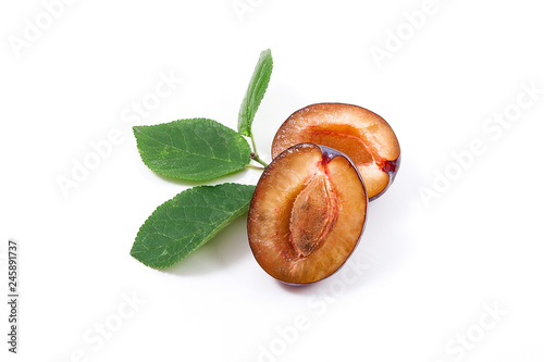 Half of ripe plum with leaf isolated on a white background..
