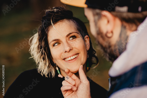 Happy couple hugging near tree in park