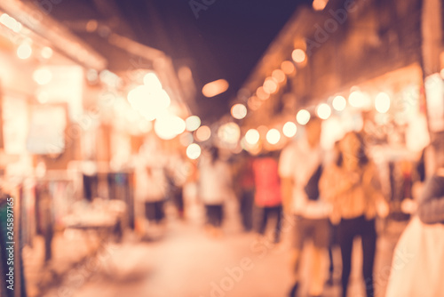 Abstract blur image of flea market and people at night with bokeh for background usage.