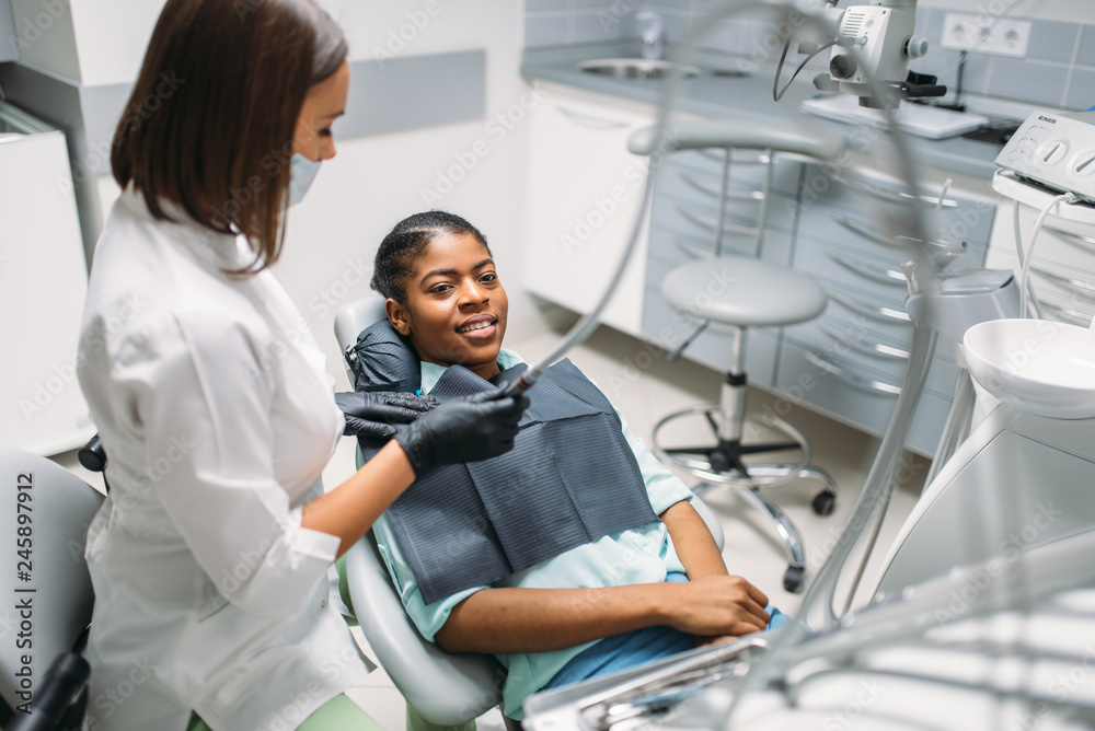 Fototapeta premium Dentist with drill treats caries, dental clinic