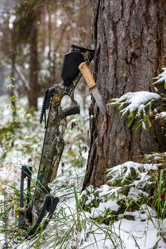  hunting tourist crossbow, a knife stuck in a pine against the background of a winter forest