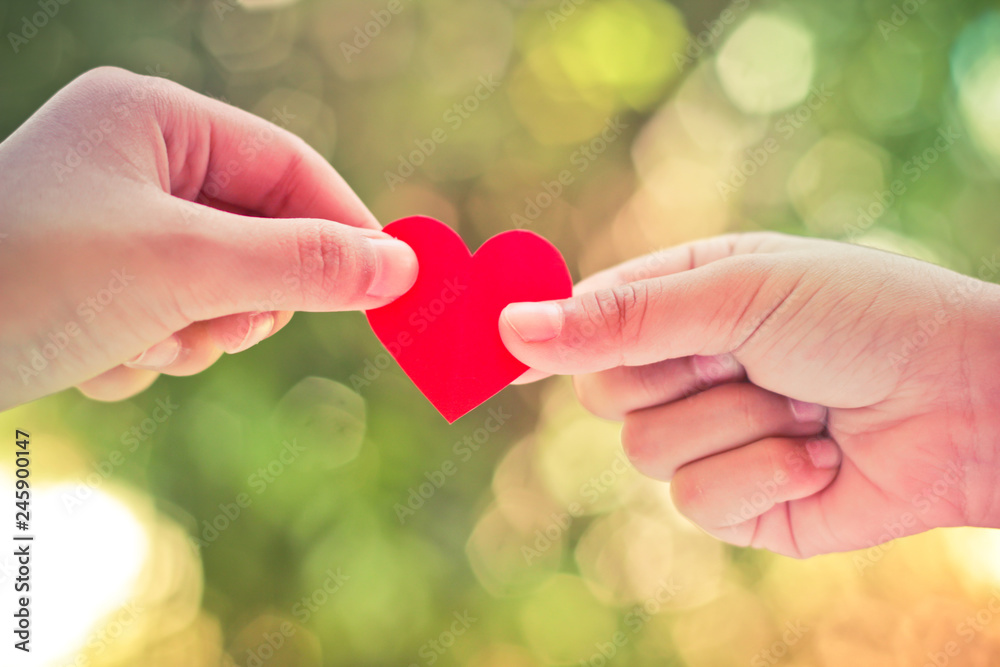 Close up hand of children holding mini heart on green background. Close up hand of children holding mini heart on green background.