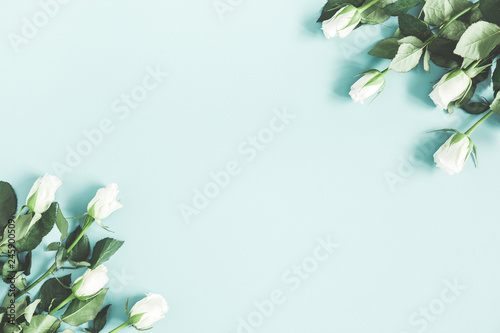 Flowers composition. White rose flowers on pastel blue background. Flat lay, top view, copy space