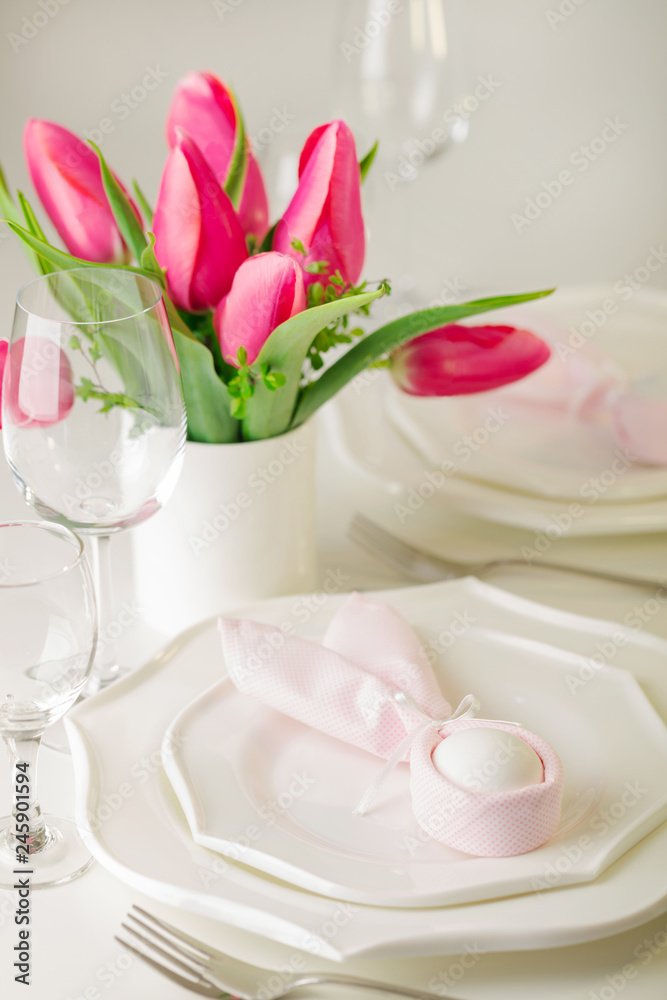 Happy easter. Decor and table setting of the Easter table is a vase with pink tulips and white dishes. Happy easter. Decor and table setting of the Easter table is a vase with pink tulips and white dishes.
