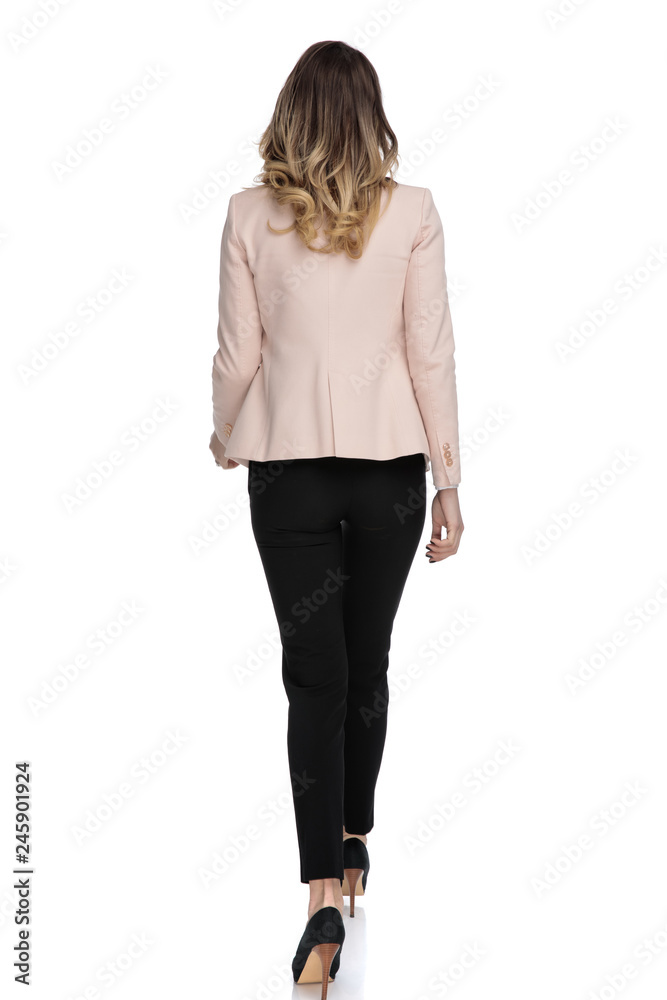 rear view of young businesswoman wearing pink suit stepping rear view of young businesswoman wearing pink suit stepping
