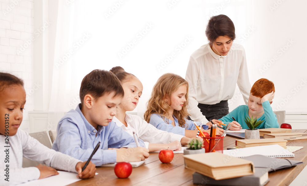 School kids doing homework with teachers help School kids doing homework with teachers help