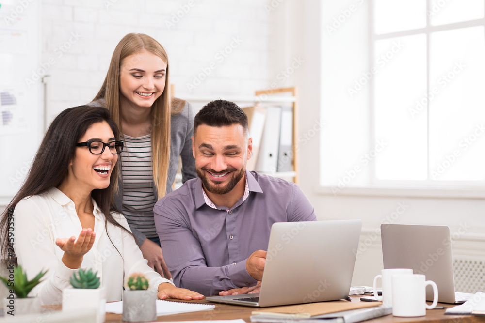 Satisfied business team working on laptop together Satisfied business team working on laptop together
