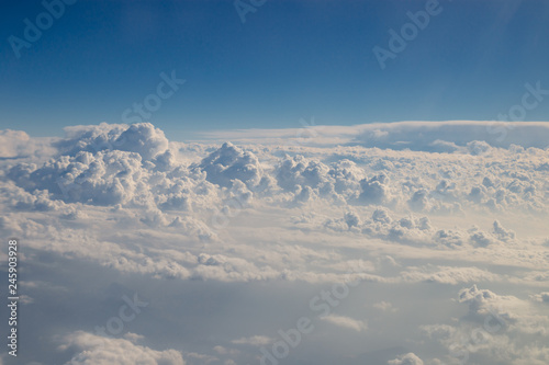 Skyline view above the clouds from airplane. © Olga Ev