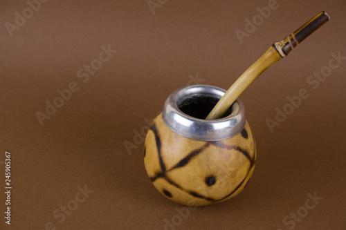 Calabas with mate herbal tea on brown background