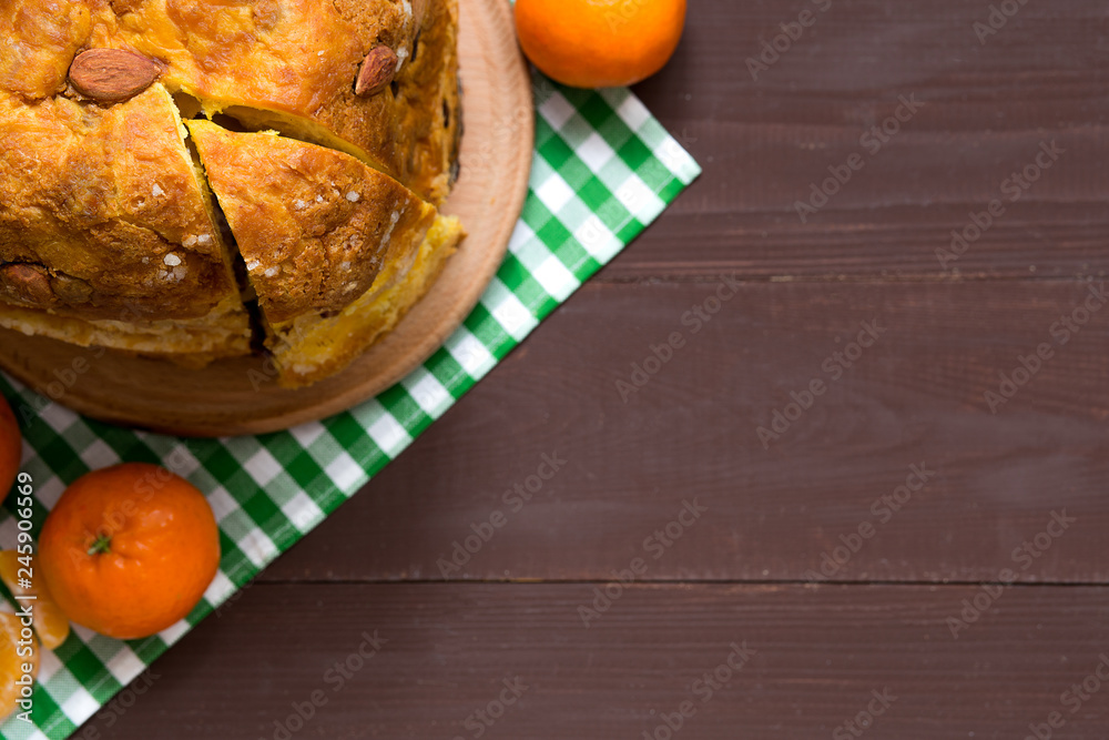 Italian traditional Christmas panettone with dried fruits and orange zest on wooden background Italian traditional Christmas panettone with dried fruits and orange zest on wooden background