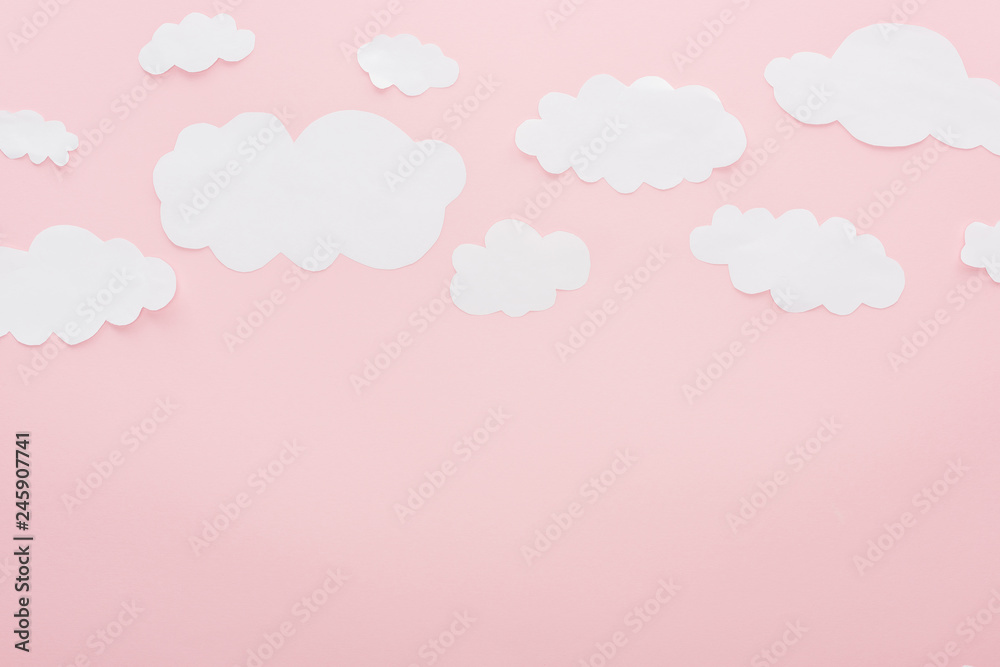 top view of white paper clouds isolated on pink with copy space