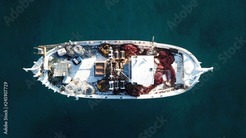 Fotografie Aerial drone bird's eye view of small traditional fishing boat in port of Mykono
