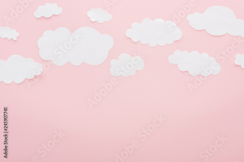 Photography top view of white paper clouds isolated on pink with copy space