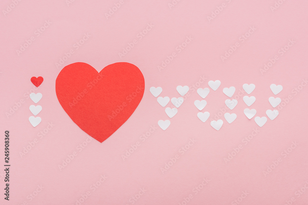 background with 'i love you' lettering made of paper hearts isolated on pink, st valentines day concept