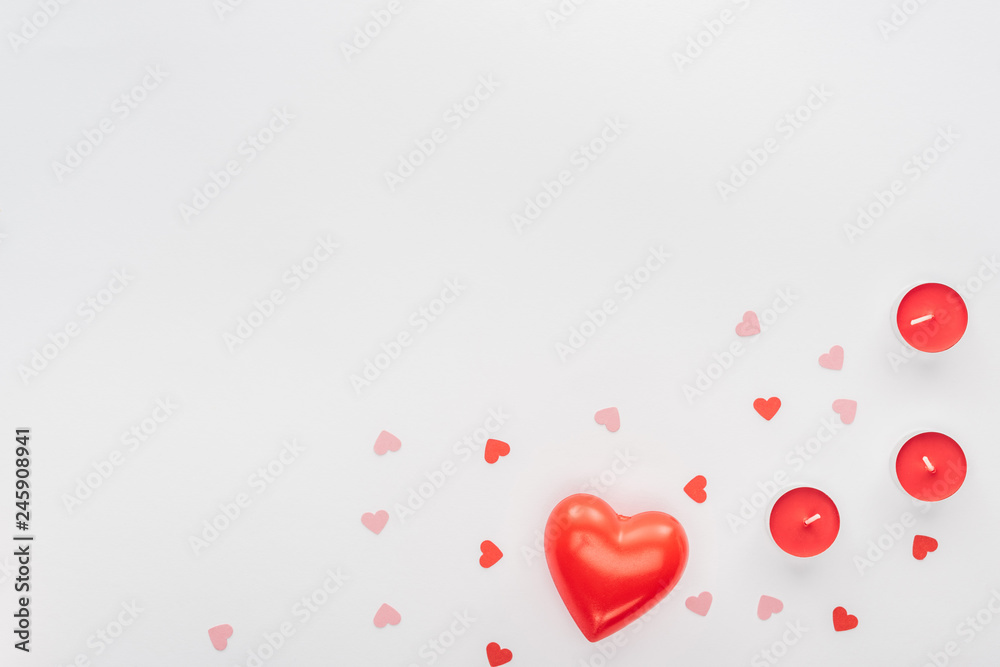 top view of red candles and paper hearts isolated on white with copy space, st valentines day concept