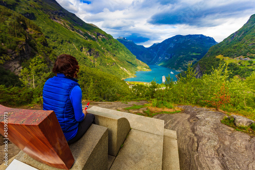 Tourist enjoying Geirangerfjord from viewing point photo