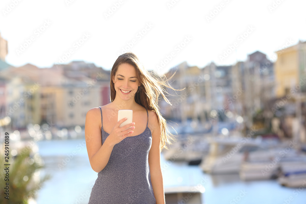 Happy woman on vacation using smart phone