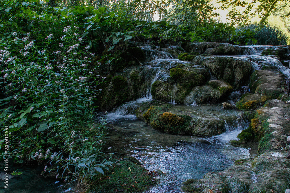 The main natural landmark of Croatia is the Plitvice Lakes with cascades of waterfalls. Emerald clear cold water on the background of rocks, plants and trees.