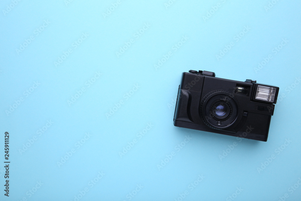 Vintage camera on blue background. Old photo camera on wooden background