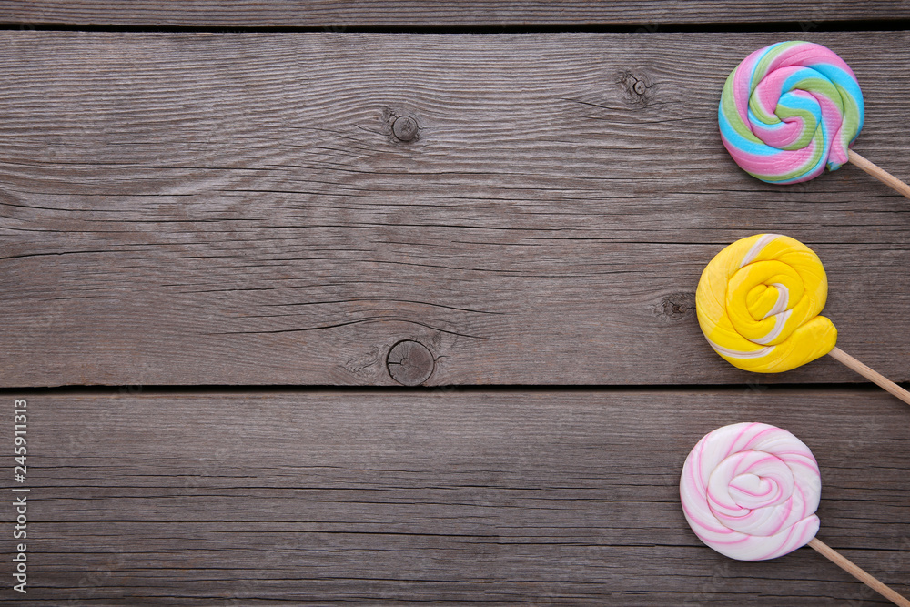 Colorful lollipops on grey wooden background, sweet candy concept Colorful lollipops on grey wooden background, sweet candy concept