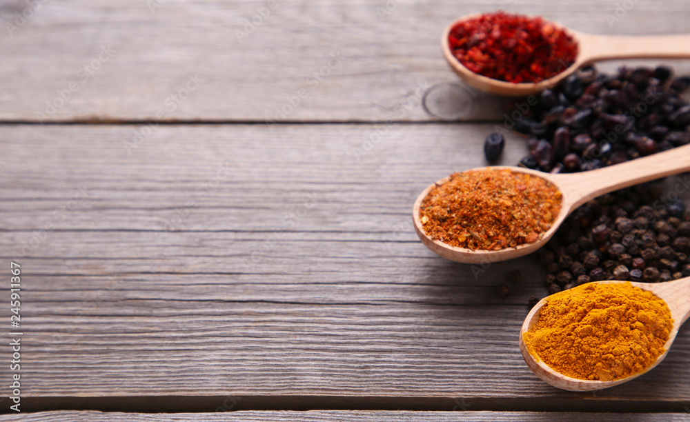 Spices mix on wooden spoons on a grey wooden background. Top view Spices mix on wooden spoons on a grey wooden background. Top view