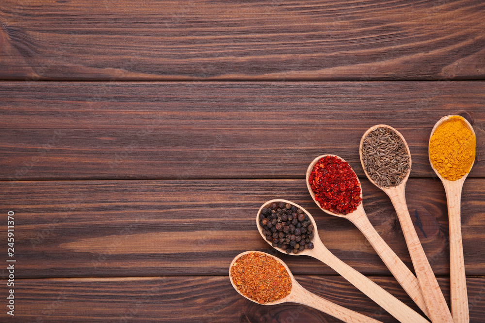 Spices mix on wooden spoons on a brown wooden background. Top view Spices mix on wooden spoons on a brown wooden background. Top view