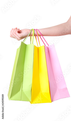 Hand holding multicolored paper bags isolated on white, shopping concept