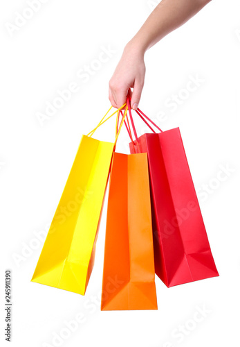 Hand holding multicolored paper bags isolated on white shopping concept