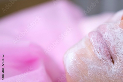 Woman's lips and nose with moisturizing mask on the cosmetology procedure. Face close-up.