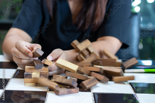 Growing business concept. Business Woman picking domino blocks for filling the missing dominus and protect domino to fail.