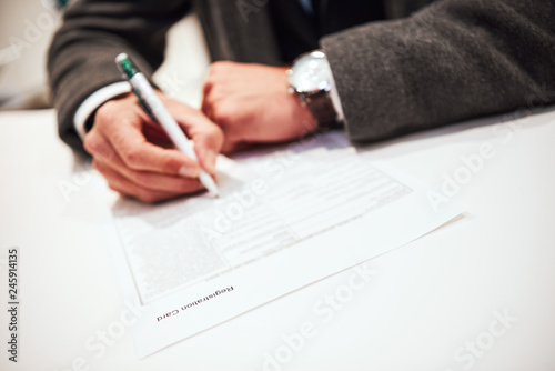 Businessman is fulfilling and signing contract with pen