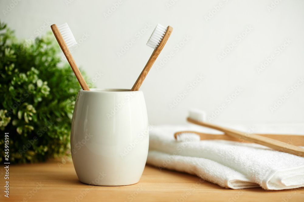 Fototapeta Bambusowe szczoteczki do zębów w szarym szkle z miejscem do kopiowania w łazience