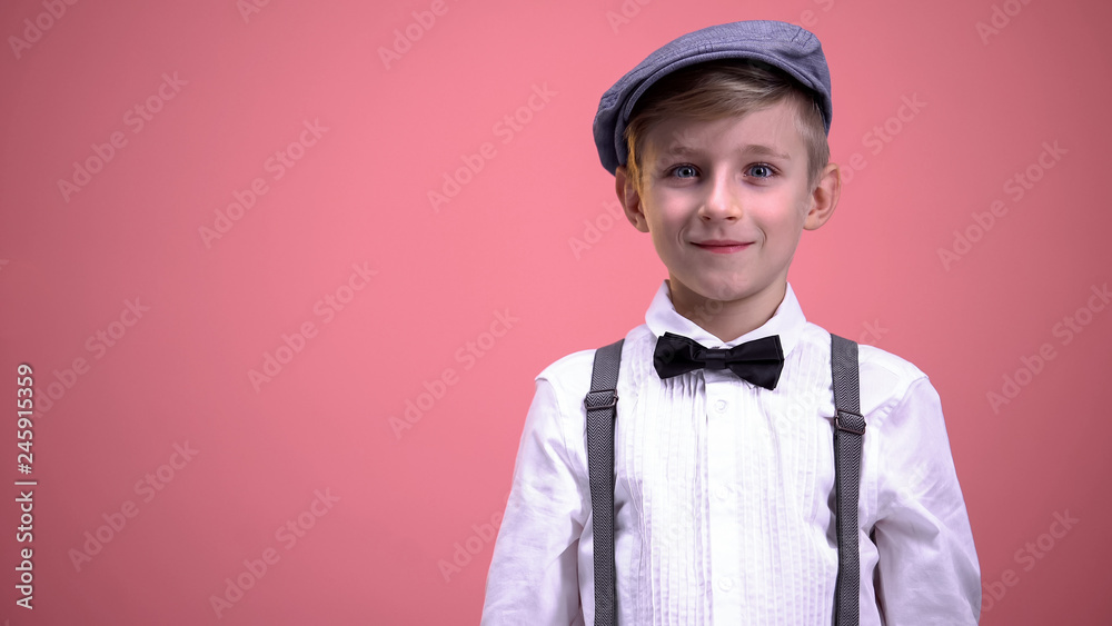 Little gentleman in vintage clothes surprisingly looking into camera, happiness