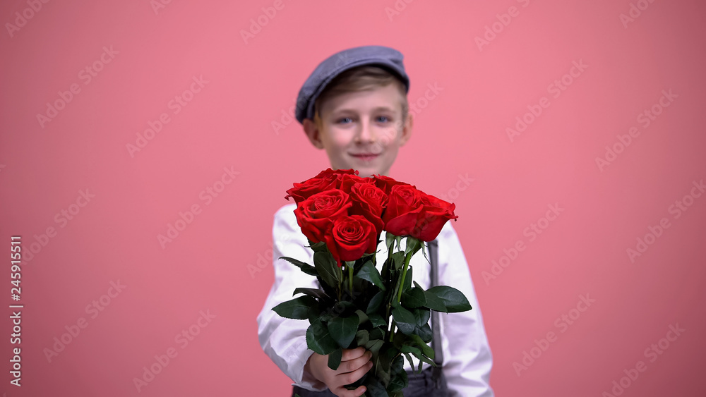 Little handsome boy showing bouquet of red roses into camera, Valentines day Little handsome boy showing bouquet of red roses into camera, Valentines day