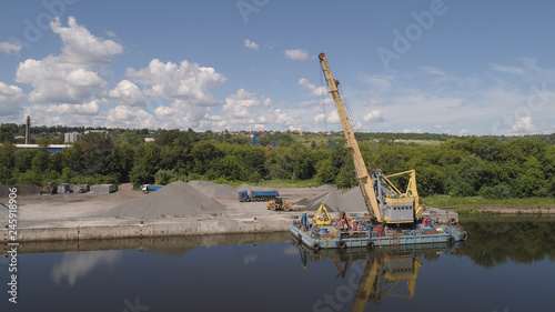 Aerial view large crane an excavator mounted on barge. Excavator on river for unloading and loading sand and rubble.