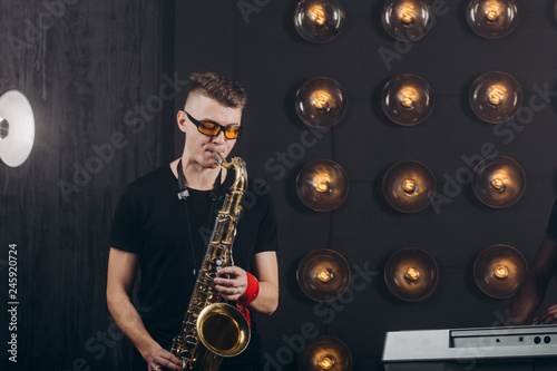 talented Caucasian guy playing the saxophone at luxury studio. copy space . free time activity