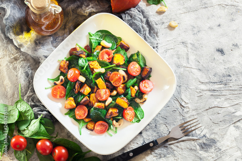 Roasted pumpkin salad with spinach, tomatoes and nuts
